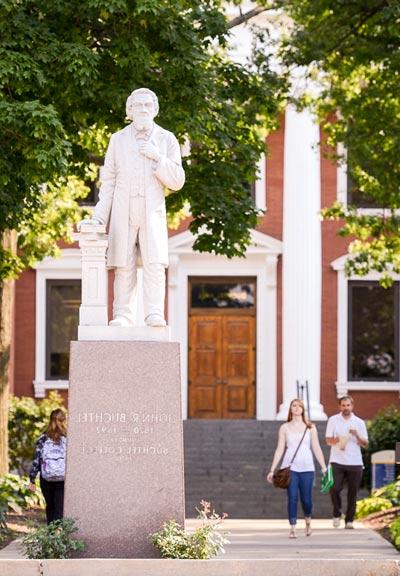 A statue of University founder John Buchtel stands before Buchtel Hall